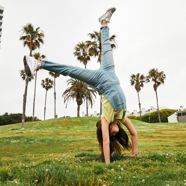 Girl Doing Cartwheels in the Park with Palm Trees in the Background