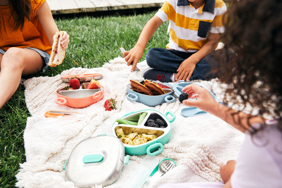 Kids enjoying a picnic with their Winck Stainless Steel Bento Lunch Boxes and To-Go Cutlery