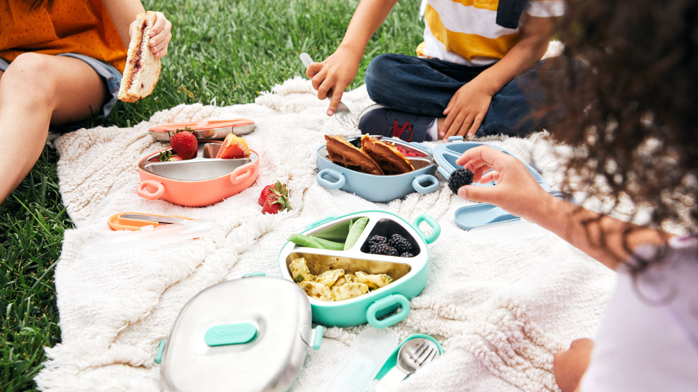 Kids enjoying a picnic with their Winck Bento Lunch Boxes and Utensil Sets