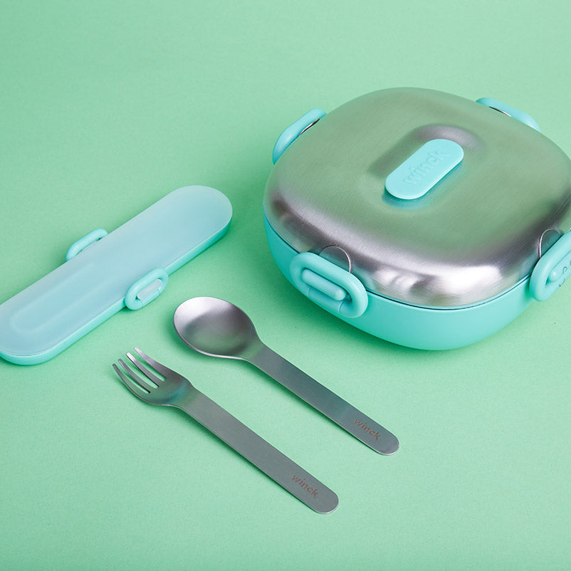 Winck Utensil Set in Pistachio with matching bento box, all arranged on a pale green background for a coordinated, eco-friendly mealtime set.